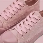 A pair of Wholesale Factory Painted Plush Solid Canvas Shoes Adult Sports Flat Sport Rubber Sneakers in pink, featuring matching laces and rubber soles, is displayed side by side on a light pink background. OEM and ODM customization available.
