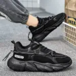 A pair of Factory Wholesale OEM ODM Summer Mesh Sneakers Men's Outdoor Anti-slip PU Rubber Sports Shoes, one worn and one on the carpet near an IKEA bag and a white metal basket—ideal for wholesale sourcing needs.