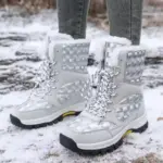 Someone is standing on snow-covered ground wearing 2024 Customized LOGO Pattern Style Autumn Winter Trendi Warm Snow Boots, featuring a mixed PU and cotton design.