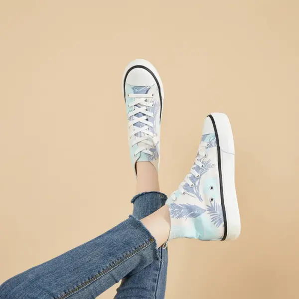 A person wearing Hot Sale Zapatos Women Casual Custom Canvas Sneaker Shoes with a blue print and blue jeans poses with feet crossed against a beige background.