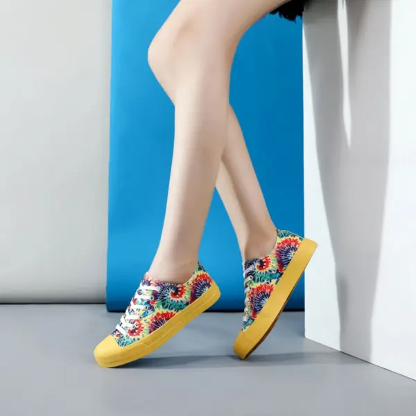 A person stands against a white and blue background, showcasing Wholesale Shoes Casual Blue Yellow Tie Dye Sport Classic Canvas Shoes, perfect for school and highlighting unique OEM/ODM footwear design options.