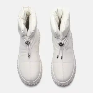 A pair of white, high-top, quilted genuine leather waterproof snow boots with plush fur lining and drawstring closures—ideal for wholesale OEM ODM customization for women’s winter footwear.