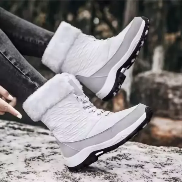A woman wears OEM Factory High Top Breathable Warm Cotton Snow Boots—winter outdoor laced PU shoes—standing on a snowy surface.