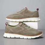 A pair of Big Size Men's Lace up Light Weight Fashion Hollow Out Breathable Flying Weaving Sports Shoes with EVA soles shown against a gray background.