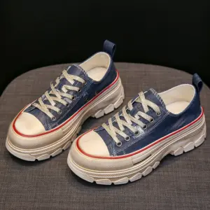 Women’s Casual Walking Style Canvas Shoes feature a navy blue canvas upper, chunky white soles, beige toe caps, and white laces—displayed on a gray fabric surface and perfect for OEM/ODM customization.