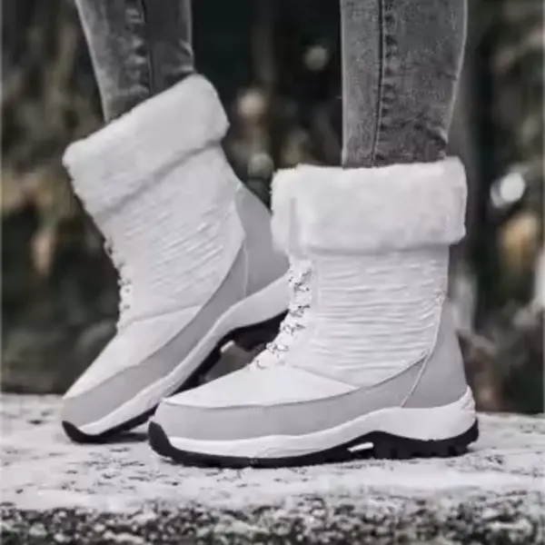 A person wears OEM Factory High Top Breathable Warm Cotton Snow Boots—laced PU women's shoes—paired with grey jeans, standing outdoors on snow, highlighting fashionable and warm winter footwear.