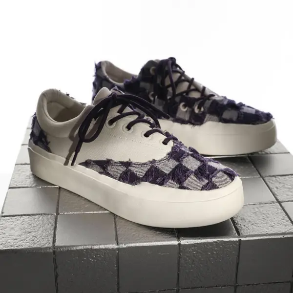 A pair of Bulk Zapatos De Hombre Custom Classic Embroidery Skateboarding Canvas Shoes for Men with white base, purple checkered pattern, white soles, and dark laces displayed on a metallic tiled surface.