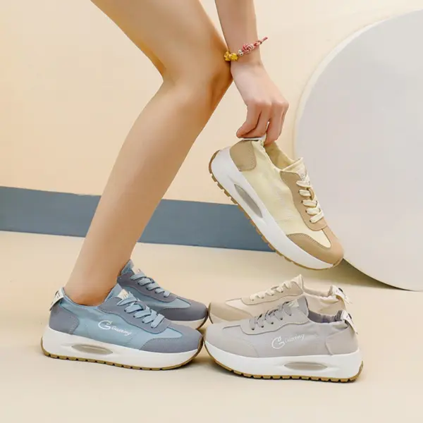 A person in light blue sneakers holds a pair of OEM ODM Durable Wearable Breathable Low Top Sneakers for women, while another gray pair lies on the floor nearby.