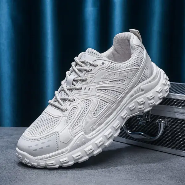 The OEM Trendy Tire Sole Men’s Light Anti-slip Wear Resistant Sneaker, featuring cotton mesh and EVA, is displayed atop a textured silver case against a blue curtain backdrop, highlighting its sporty chunky sole design for ODM or OEM orders.