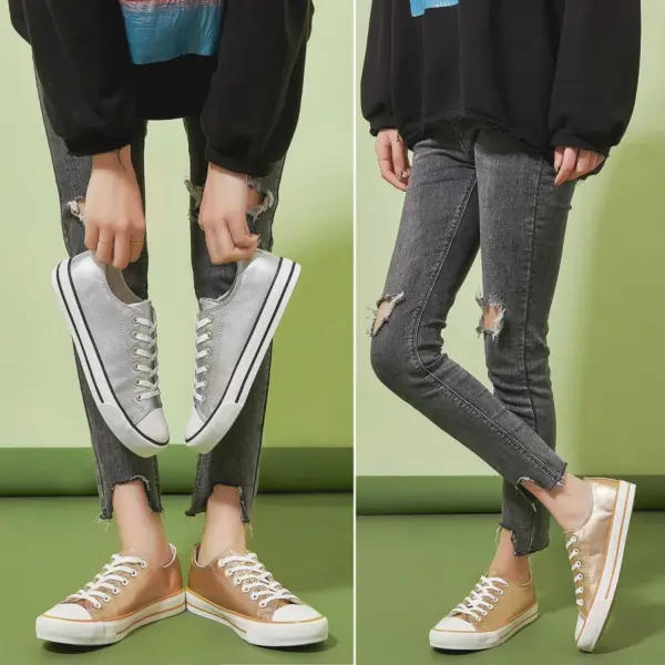 Two images show a person in black jeans and a black top wearing metallic Hot Sale Customize Fashionable PU Upper Women's Canvas Shoes, holding a silver pair and wearing a gold pair, against a green background.