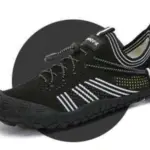 A black minimalist Customized Anti-slip Quick Drying Outdoor Shoe with white stripes, mesh upper, elastic laces, and textured rubber sole is displayed on a dark circular background—ideal for OEM ODM customization.