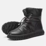 A pair of black plush, thick genuine leather waterproof fur boots with drawstring closure and textured rubber soles—perfect for OEM/ODM customization as women's snow winter boots.