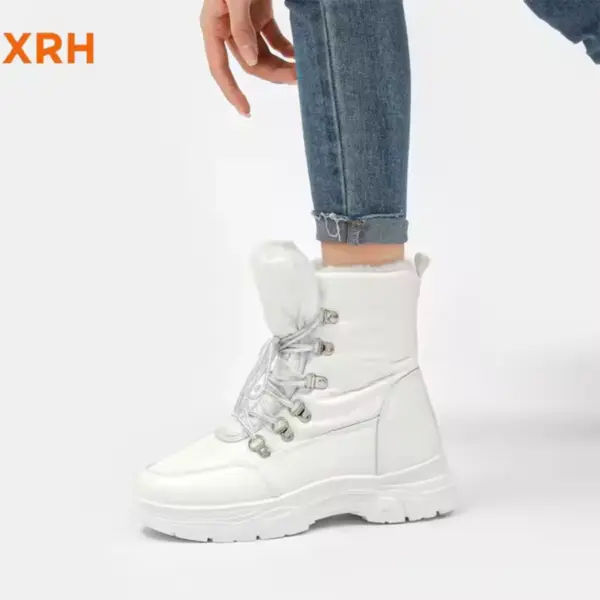 A person wearing New Arrivals Waterproof Zipper Anti-Slip Adjustable Lace-Up PU Upper Fur Lined Warm Women's Snow Winter Boots with rolled-up blue jeans stands against a plain white background.