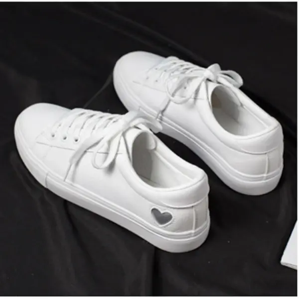A pair of Xrh Wholesale Spring PU Valentine's Day Gift Love Custom Low Top Vulcanize White Shoes for women, featuring a small heart on the heel, displayed on a black surface.