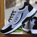 A pair of gray and black High Quality Gym Casual Cushioning Sneakers for men, featuring "FASHION" on the side, displayed on a wooden surface.