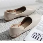 A pair of Slingbacks Square Flat Shoes for Women in beige, suitable for OEM ODM orders, is displayed on a textured carpet beside an open magazine and a fringed blanket.