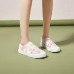 A person wearing XRH Wholesale Cheap Price Pink Slip on Women's Casual Canvas Shoes for Women New Style 2025 stands on a green surface.