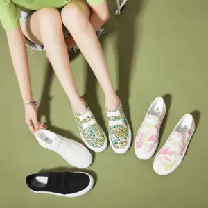 A person on a green floor tries on XRH Wholesale Pink Slip-on Women's Casual Canvas Shoes, with OEM ODM options—two other pairs in unique patterns and one solid black pair beside them.