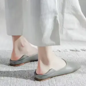 A person wearing Slingbacks Square Flat Shoes for Women in light grey and white pants stands on a textured, light-colored surface.