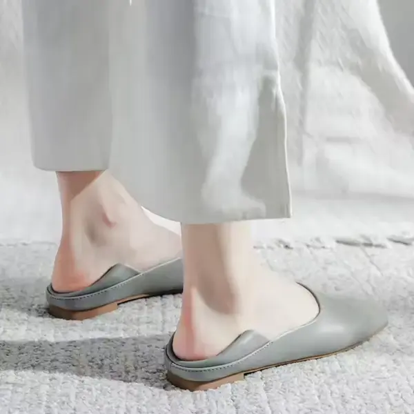 A person wearing Slingbacks Square Flat Shoes for Women in light grey and white pants stands on a textured, light-colored surface.
