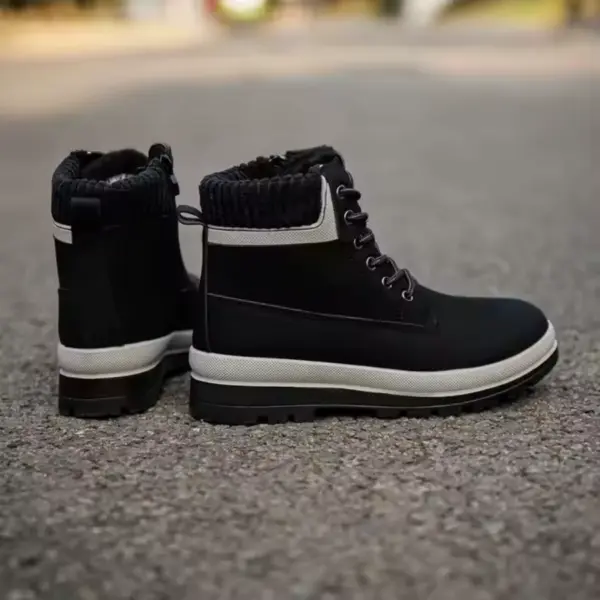 A pair of 2025 New Arrivals Winter Snow White Boots for Women and Men, custom height increasing lace-up leather boots, are displayed on asphalt—perfect for OEM ODM footwear collections.