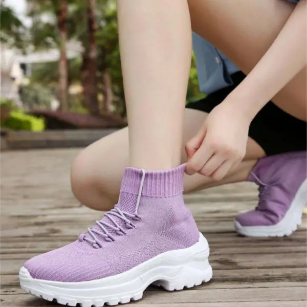 A woman outdoors adjusts her XRH Wenzhou Factory Thick Bottom Increase High Top Chunky Sneakers—sock-style, light purple knit shoes with thick white soles, perfect for casual running and walking.