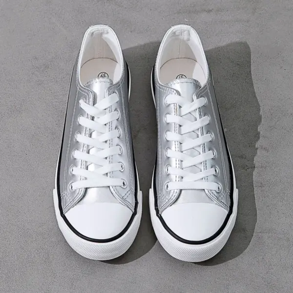 A pair of Hot Sale Customize Fashionable PU Upper Women's Canvas Shoes, lightweight and trendy with white laces and rubber toe caps, are placed side by side on a gray surface.