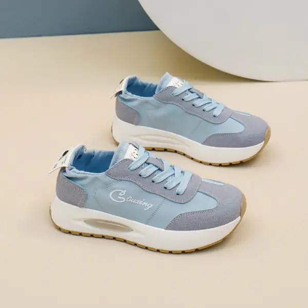 A pair of OEM ODM Durable Wearable Breathable Low Top Sneakers for women with white soles and blue laces, designed for outdoor walking, displayed on a beige surface.