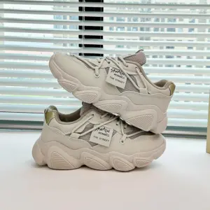 A pair of Women's Low Top Mesh Thick Sole Height Increasing Wear Resistant Outdoor Sports Sneakers are stacked on a tabletop in front of a window with horizontal blinds.