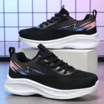 A pair of 2024 Custom Mesh Sneakers Sport Women Running Shoes, black with white soles and blue and pink accents, are displayed on a gray grid-patterned surface. Fashionable, breathable sneakers for women and ladies.