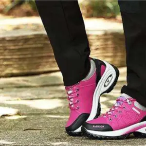 A person wearing black pants and Customizable 2024 Walking Shoes—microfiber PU, EVA, round toe, breathable rubber men’s sports shoes—stands outdoors on a paved surface.