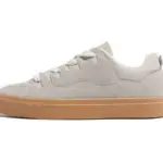 A side view of the Customizable Retro Mixed Stylish Plush Walking Sneakers for women shows their beige suede, lightweight design with white laces, a light brown rubber sole, and highlights OEM/ODM versatility.