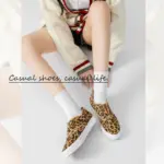 Woman sitting cross-legged wears a cream sweater, white socks, and Hot Sale Casual Low Top No Lace Lazy Canvas Shoes with Random Fluff Decoration. Text overlay: "Casual shoes, casual life.