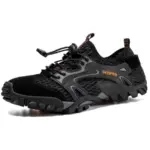 Black outdoor hollow mesh hiking shoe with anti-slip EVA rubber sole, adjustable bungee laces, "FASHION" text on the side, and available for OEM/ODM wholesale customization.