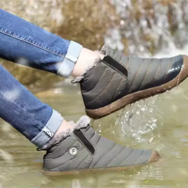 Wearing gray Factory Wholesale OEM ODM low top waterproof outdoor cotton snow boots, a person in rolled-up blue jeans splashes water in a shallow stream.