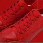A pair of Wholesale Factory Painted Plush Solid Canvas Shoes—adult sports flat sneakers with rubber soles—side by side on a red background, ideal for OEM ODM customization to match your brand’s unique style.