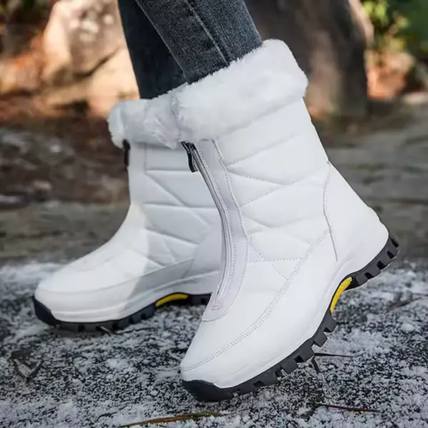 A person wearing Wholesale Custom Winter Trendy Waterproof Snow Boots Plush Large Size Zipper Outdoor Women's Shoes stands on a partially snowy ground.