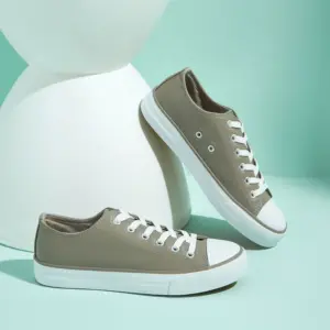 Hot Sale customizable women's fashionable PU upper canvas shoes with lightweight white soles and toe caps, shown on a mint green surface with a modern white prop—ideal for OEM/ODM orders.