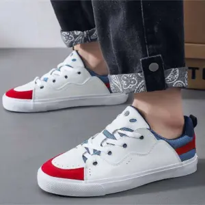 A person wearing Customizable Retro Mixed Stylish Plush Walking Sneakers—lightweight, breathable women’s shoes—paired with black jeans that have patterned cuffs.