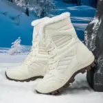 A pair of OEM ODM 2025 large size round toe PU TPR snow boots, warm and cotton-lined for daily wear, are placed on snow with a snowy landscape in the background.