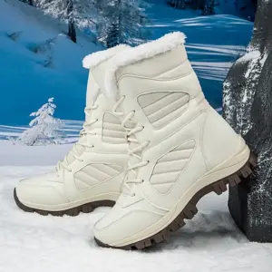 A pair of OEM ODM 2025 large size round toe PU TPR snow boots, warm and cotton-lined for daily wear, are placed on snow with a snowy landscape in the background.