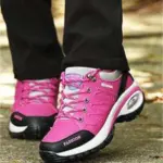 A person in Customizable 2024 Walking Shoes—microfiber PU, EVA sole, round toe, breathable rubber—walks on a paved path.
