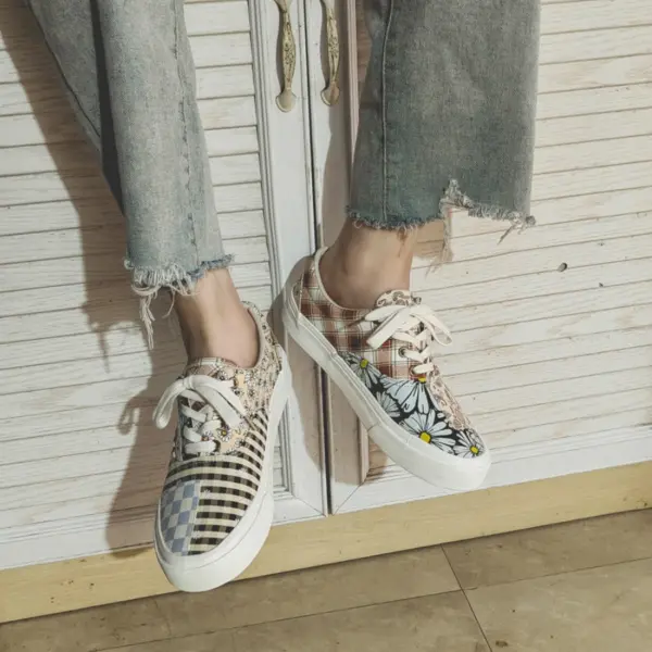 Wearing Wholesale Mixed Wearable Canvas Shoes—lace-up, breathable, low-top sneakers with floral, checkered, and plaid designs—this person sits by a white wooden cabinet, perfect for unique OEM ODM footwear needs.