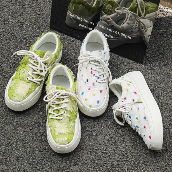 Two pairs of Bulk Zapatos De Hombre custom classic embroidery skateboarding canvas shoes—one green and frayed, one white with colorful dots—showcase unique OEM/ODM designs beside a reflective sign.