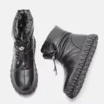 A pair of black Wholesale Customized Plush Thick Genuine Leather Waterproof Bread Cotton Fur Boots for Women snow boots with drawstring closures and textured rubber soles, displayed against a plain white background.