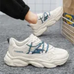 Sporty white men’s walking sneakers made from PU mesh with blue laces and “FASHION” on the side, paired with black pants near a wire basket—ideal for OEM/ODM customization. Wholesale factory solid color daily outdoor shoes.