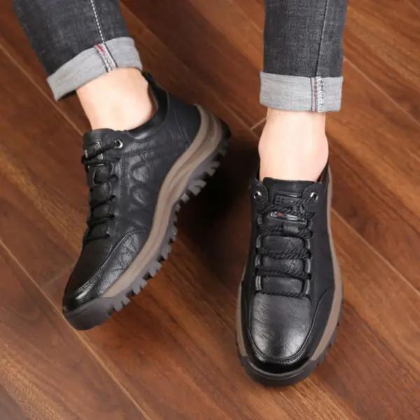 A person wearing Men's Solid Faux Leather Lace up Shoes Sneakers for Men High Quality Walking Style Shoes stands on a wooden floor, jeans rolled up at the ankles.