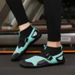 Wearing OEM ODM Outdoor Waterproof Sport EVA Breathable Water Shoes in aqua and black, paired with black leggings, while standing on a treadmill.