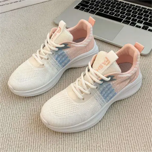 A pair of Factory Custom Spring New Styles Women's Sports Sneakers—chunky, non-slip, white with light pink and blue accents—rests on a beige carpet next to a silver laptop.