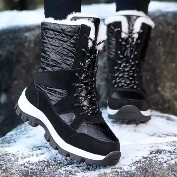 A person stands on snow-covered rocks wearing Wholesale Mountain Outdoor Hiking Wear Resistant Women's Snow Boots—TPR EVA thick-soled cotton shoes designed for OEM ODM production.